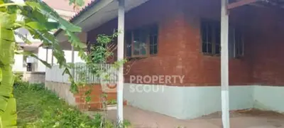 Charming brick exterior house with lush greenery and inviting porch.