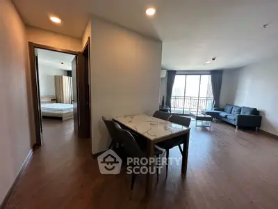 Spacious modern apartment with open living and dining area, featuring a large window and elegant furnishings.