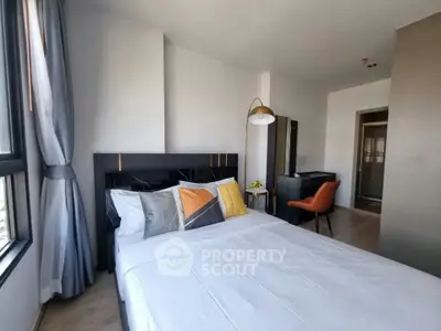 Modern bedroom with stylish decor and large windows offering natural light.