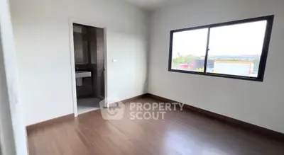 Spacious bedroom with ensuite bathroom and large window offering natural light.