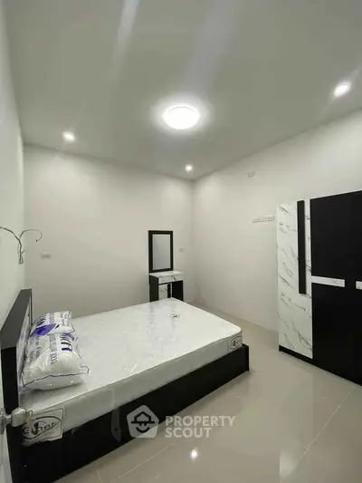 Modern minimalist bedroom with sleek furniture and bright lighting