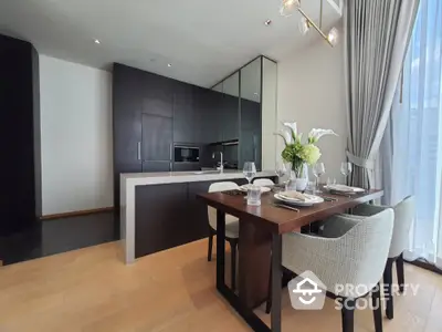 Modern kitchen and dining area with sleek dark cabinetry and elegant dining setup