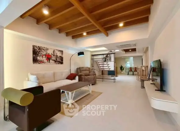 Spacious modern living room with stylish decor and wooden ceiling beams