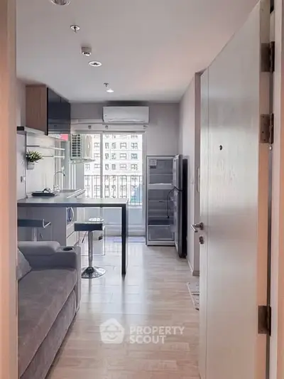 Modern open-layout kitchen with sleek appliances and cozy living area, perfect for urban living.