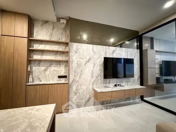Modern living room with marble accents and wall-mounted TV in a stylish apartment.