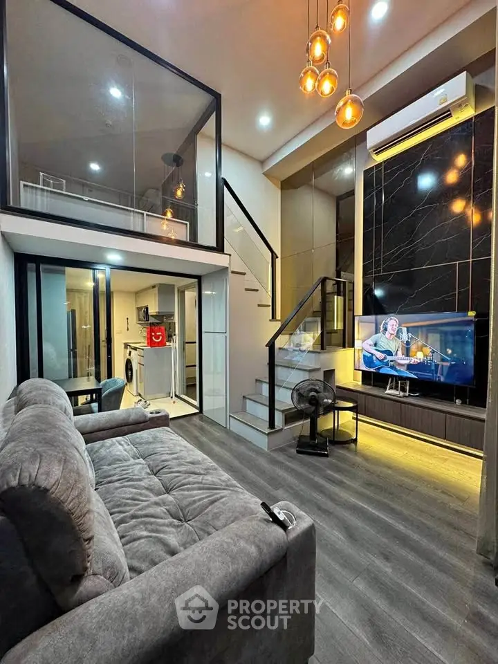 Modern living room with loft, stylish lighting, and sleek design in a contemporary apartment.