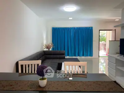 Modern living room with sleek black sofa and vibrant blue curtains