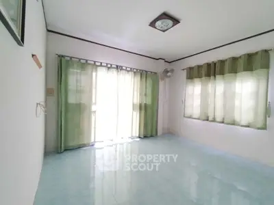 Spacious empty room with large windows and green curtains, perfect for customization.