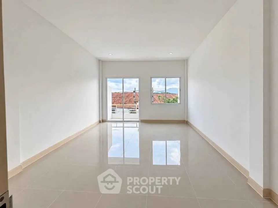 Spacious unfurnished room with large windows and glossy tiled floor