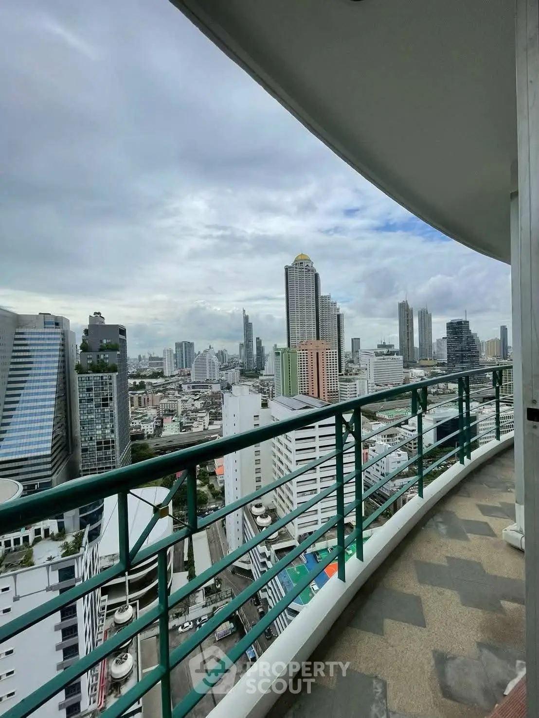Stunning cityscape view from a high-rise balcony with modern railing.