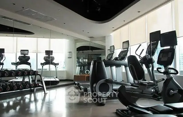 Modern gym with state-of-the-art equipment and city view windows.