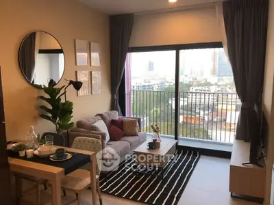 Modern living room with large window and city view, featuring stylish decor and cozy seating area.
