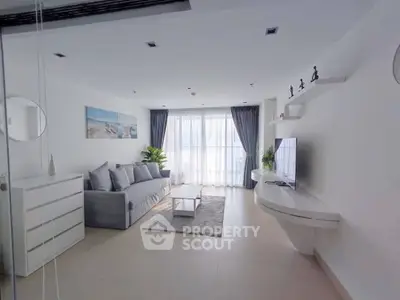 Modern living room with sleek furniture and large windows for natural light.