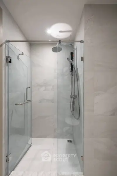 Modern bathroom with sleek glass shower enclosure and elegant tile design.