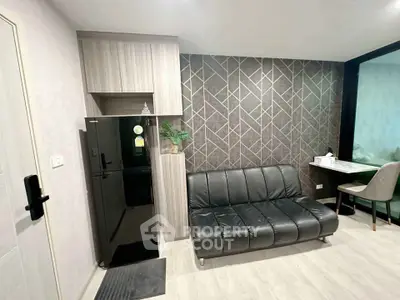 Modern living room with sleek black sofa and stylish geometric accent wall