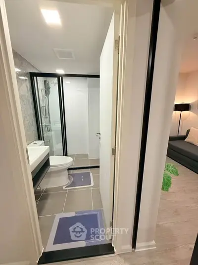 Modern bathroom with sleek design and adjacent cozy living area