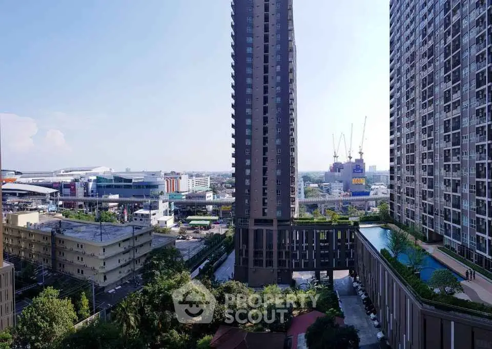 Stunning urban view from high-rise building with pool and cityscape backdrop.