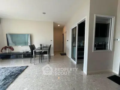 Modern living room with dining area and sleek kitchen, featuring elegant marble flooring and contemporary decor.