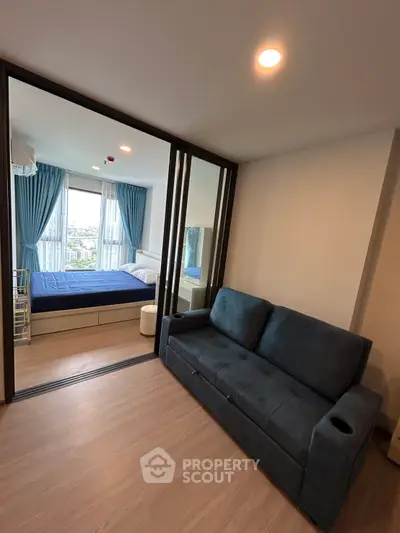 Modern apartment with cozy living room and bedroom, featuring large windows and stylish furnishings.