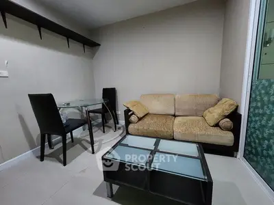 Cozy living room with modern glass table and comfortable sofa, perfect for relaxation.