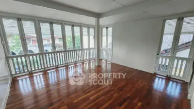 Spacious corner unit with elegant wooden flooring and abundant natural light from large windows.