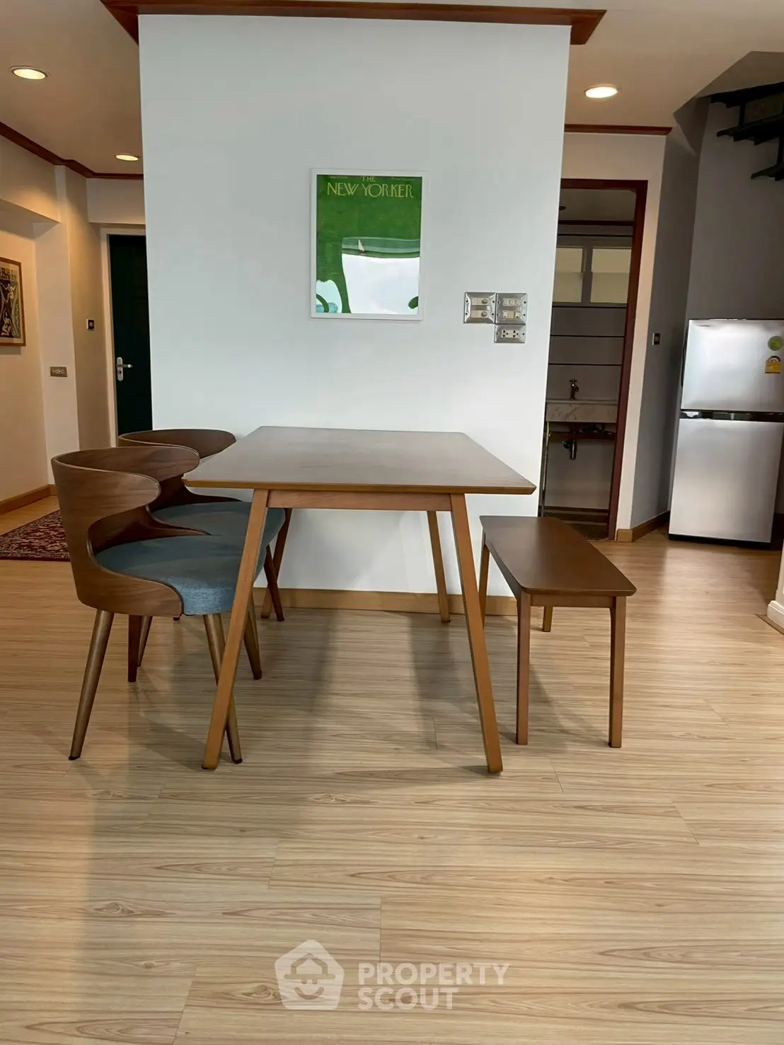 Modern dining area with wooden table and chairs, stylish decor, and sleek flooring.
