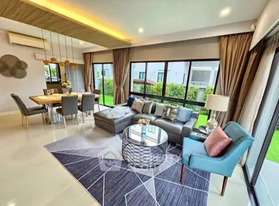 Spacious modern living room with large windows and elegant decor in a luxury home.