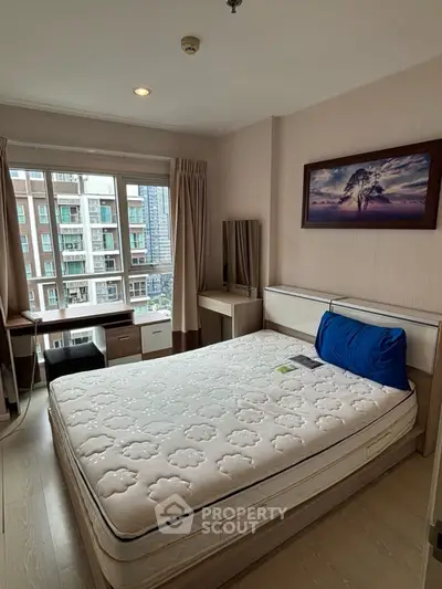 Cozy bedroom with large window and modern furniture in urban apartment