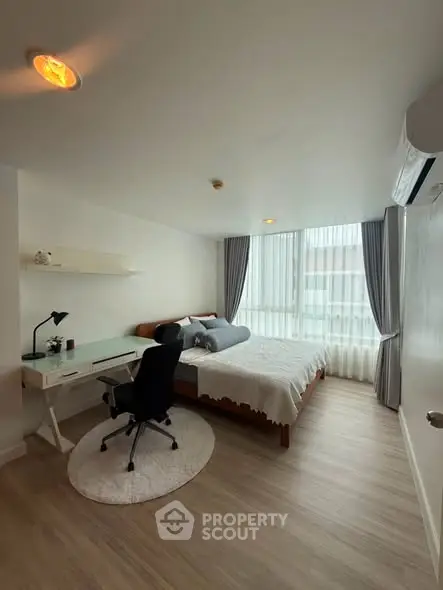 Modern bedroom with study area, featuring large window and stylish decor.