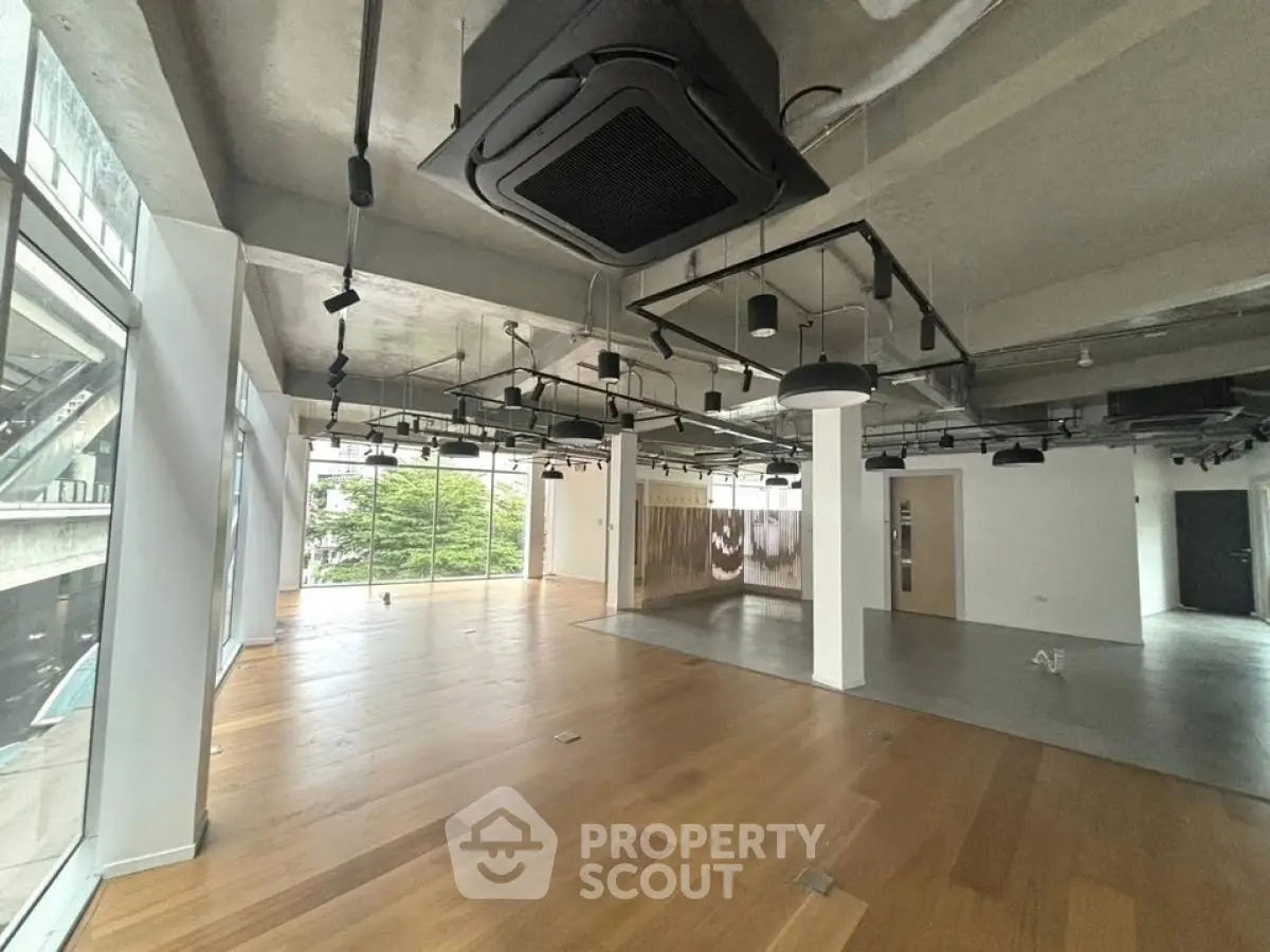 Spacious modern office space with large windows and wooden flooring