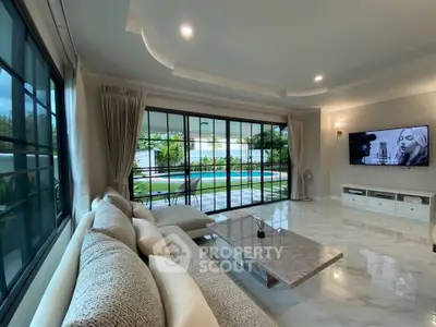 Luxurious living room with pool view, elegant marble flooring, and modern decor in a spacious open layout.