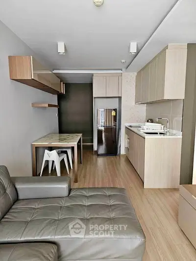 Modern open-layout kitchen and living area with sleek furniture and appliances.