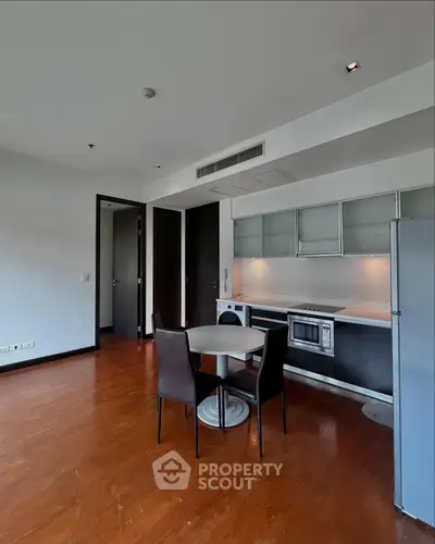 Modern kitchen with sleek cabinetry and dining area in open layout apartment.