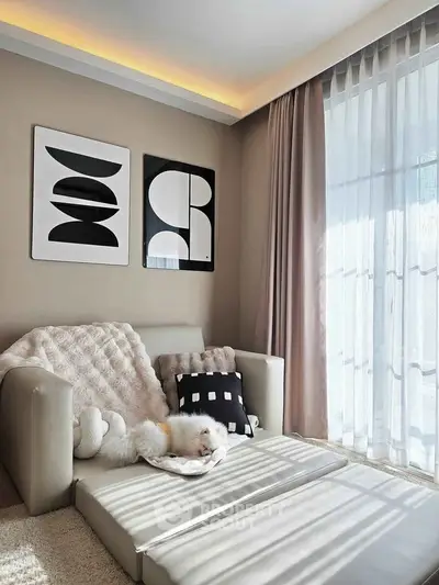 Cozy living room with modern decor and natural light, featuring stylish artwork and comfortable seating.
