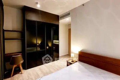 Modern bedroom with sleek wardrobe and cozy lighting in a stylish apartment.