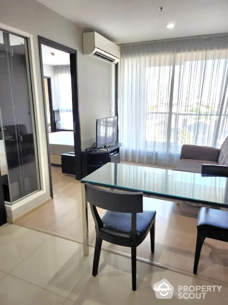 Modern living room with glass table and large windows in stylish apartment