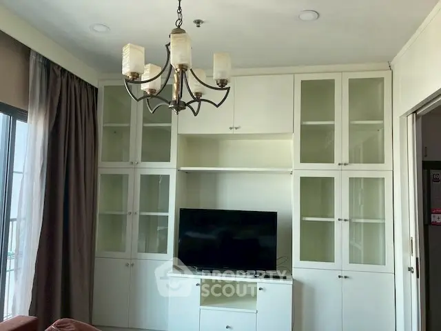 Elegant living room with built-in cabinets and modern chandelier, perfect for stylish urban living.