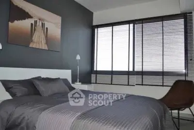 Modern bedroom with stylish decor and large window blinds