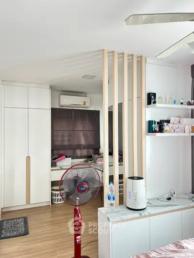 Modern bedroom with sleek storage and stylish decor, featuring a ceiling fan and air conditioning for comfort.