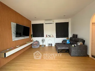 Modern living room with sleek design, featuring a wall-mounted TV and comfortable seating area.