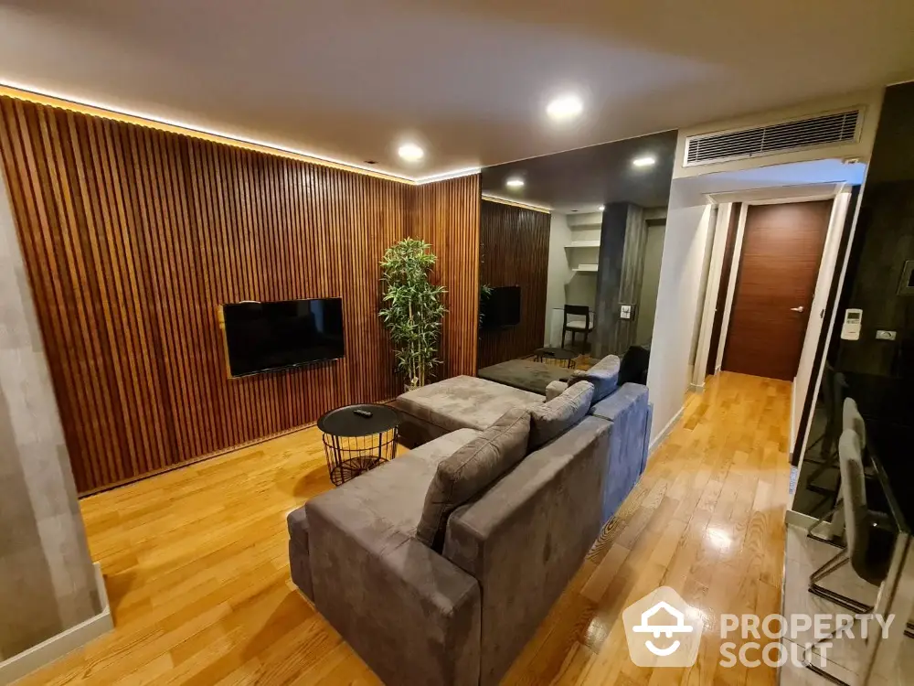 Modern living room with wooden accent wall and cozy gray sofa