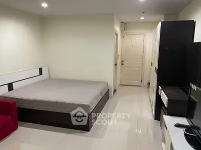 Spacious bedroom with modern furnishings and sleek tile flooring in a contemporary apartment.