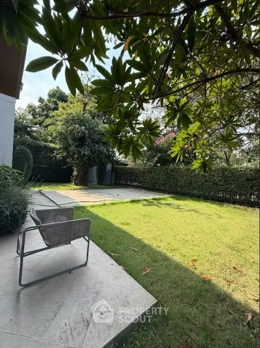 Spacious garden with lush greenery and cozy seating area, perfect for relaxation and outdoor activities.