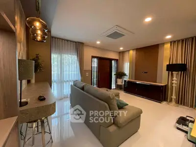 Modern living room with stylish decor and natural light, featuring a comfortable sofa and elegant lighting.