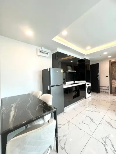 Modern kitchen with sleek black cabinets and marble dining table in stylish apartment.