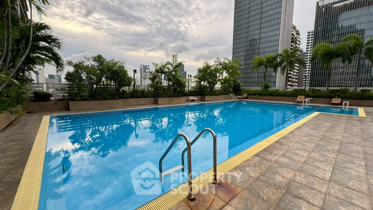 Luxurious rooftop pool with stunning city skyline views and lush greenery.
