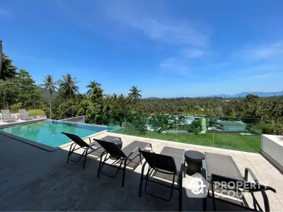 Luxurious outdoor pool area with stunning panoramic view of tropical landscape and clear blue sky.