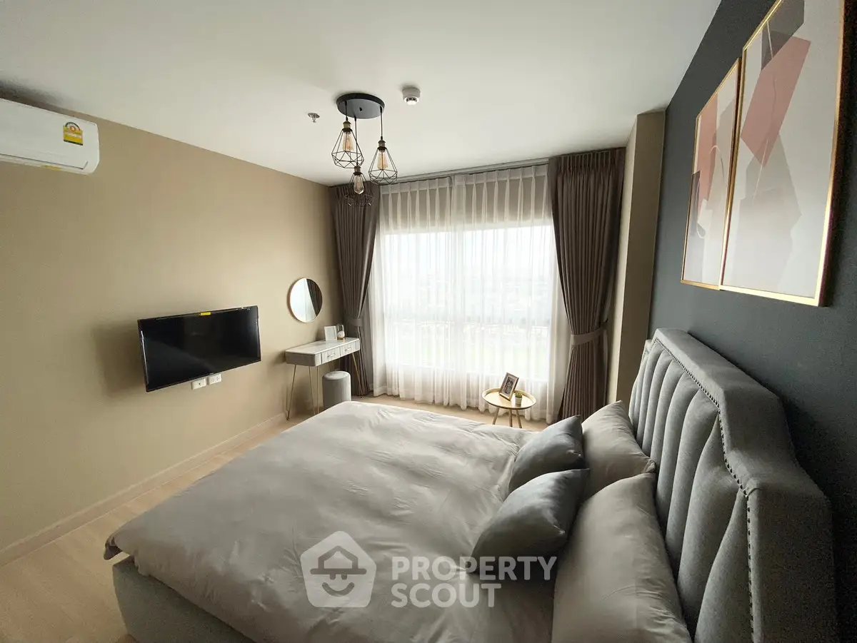 Modern bedroom with stylish decor and large window offering natural light