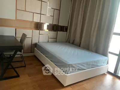 Modern bedroom with stylish decor and natural light, featuring a sleek bed and elegant furnishings.