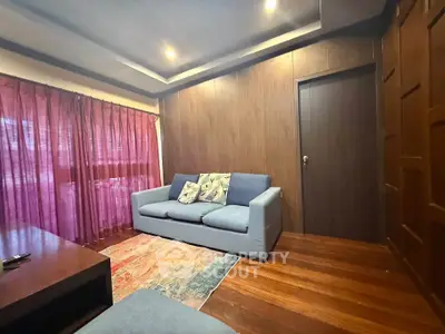 Cozy living room with wooden walls and modern blue sofa